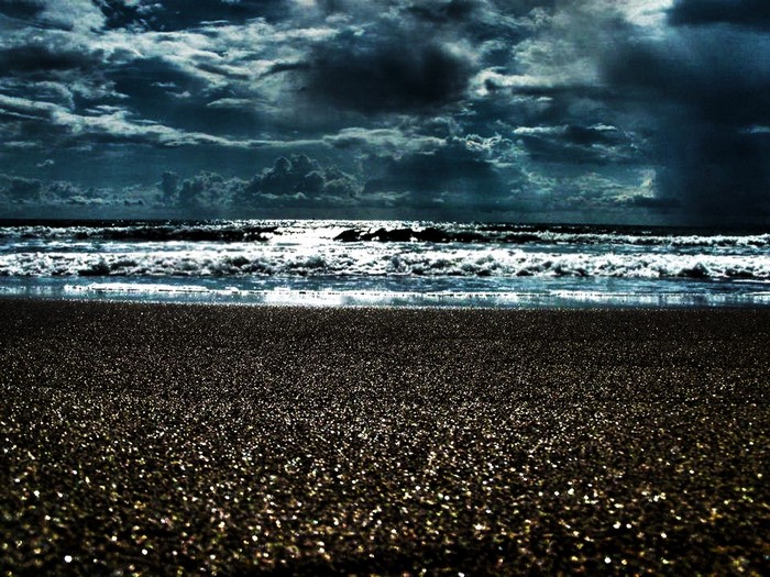 Dark stormy clouds over a beach with waves