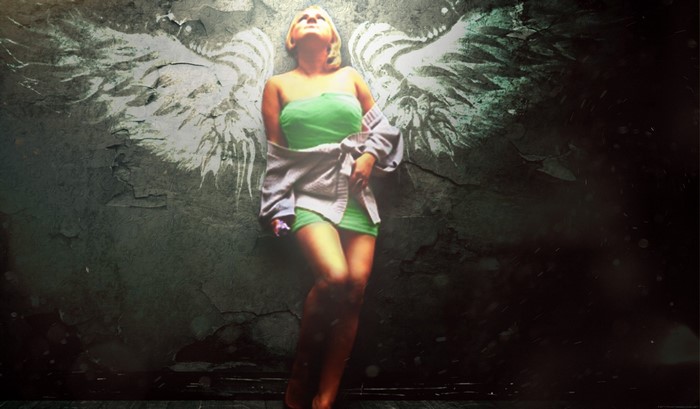 Woman with angel wings against a textured wall