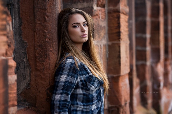 Woman with long brown hair wearing a plaid shirt