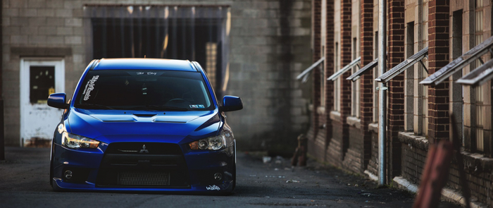 Blue Mitsubishi Lancer EVO parked in an alley