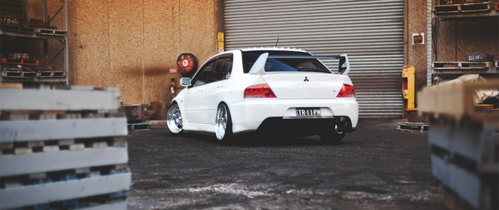 White Mitsubishi Lancer EVO parked in industrial area