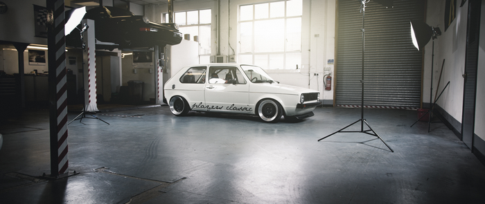 White Volkswagen Golf GTI in a garage with studio lighting