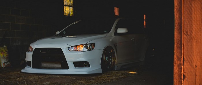 White Mitsubishi Lancer Evolution parked in a barn