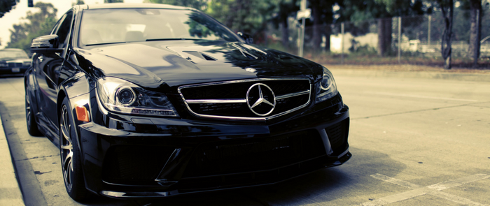 Black Mercedes-Benz C-Class parked on the side of the road