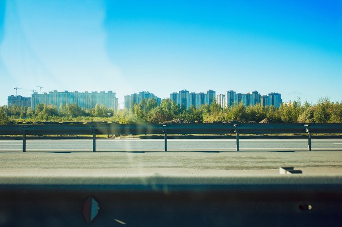 Apartment buildings and trees along a highway