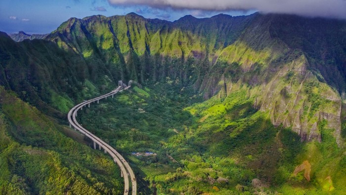 Highway through a lush green mountain valley in Hawaii