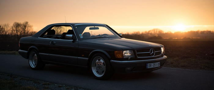Dark Mercedes Benz SEC coupe at sunset