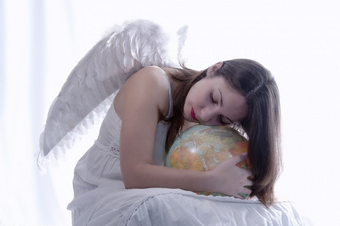 Woman with angel wings holding a globe