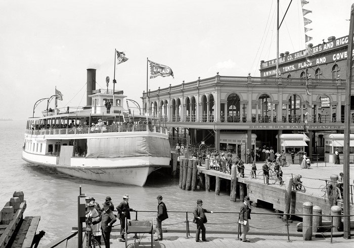 Ferry boat docked at a pier with people and buildings