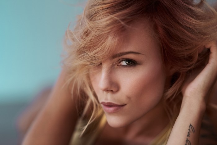 Woman with blonde hair and tattoo on arm