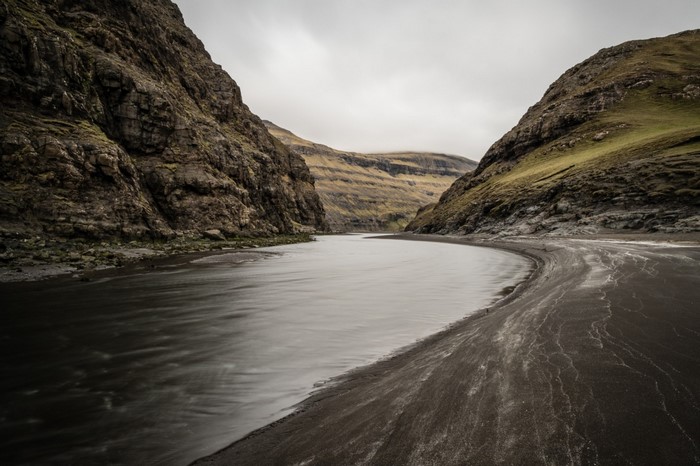 River flowing between rocky mountains in Faroe Islands