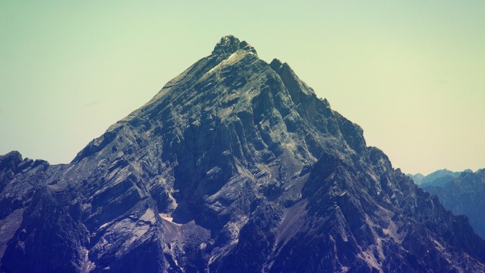 Jagged mountain peak under a pale sky
