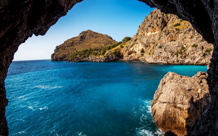 Scenic Sea Cave Overlooking Rocky Bay and Clear Blue Water