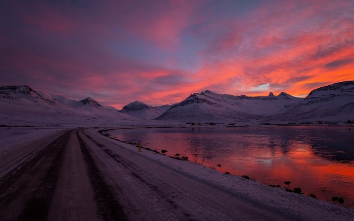 Snowy mountains and lake at sunset with colorful sky