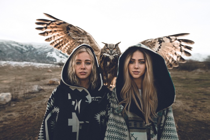 Two girls with an owl in a mountainous landscape