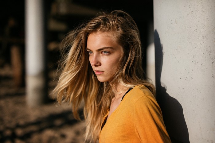 Woman with long blonde hair in an orange shirt
