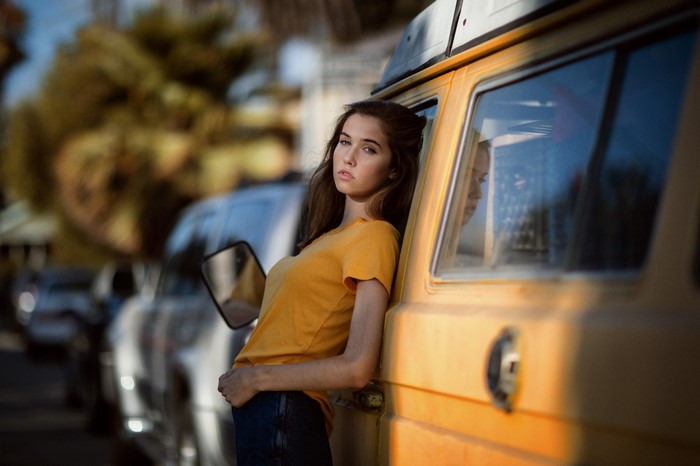 Woman leaning on a yellow van