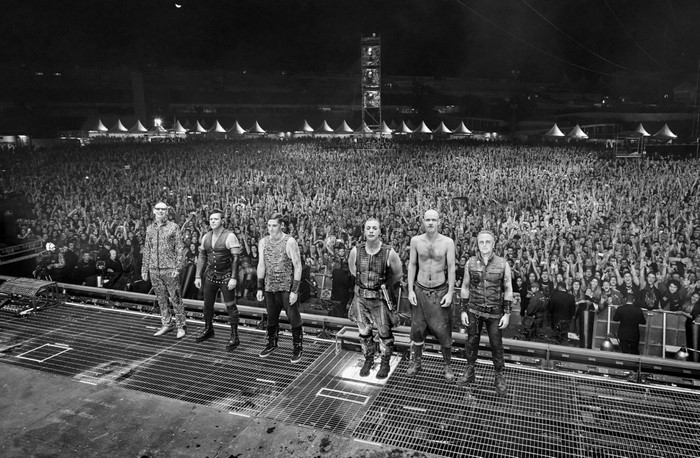 Rammstein band members on stage with a large crowd
