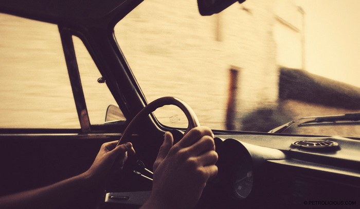 Hands on the steering wheel of a vintage car