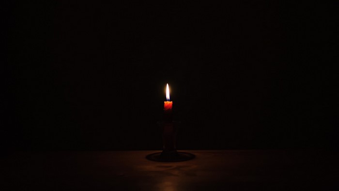 A single lit candle in a dark room