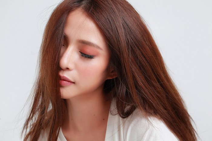 Woman with long brown hair and makeup