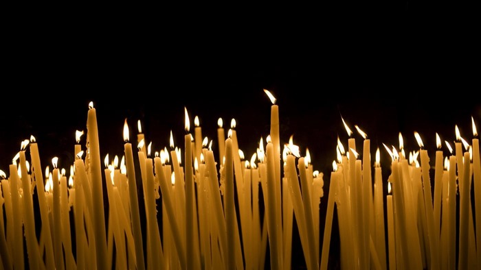Many lit candles in the dark