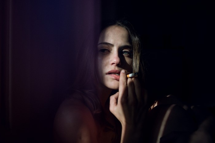 Woman smoking a cigarette in the dark