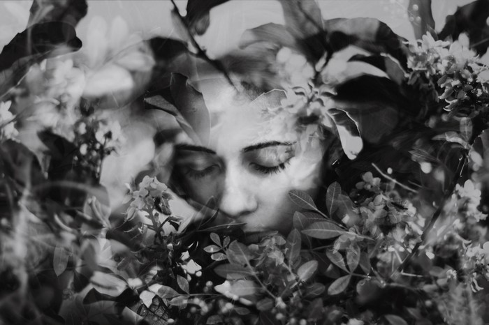 Monochrome double exposure of a woman's face and flowers