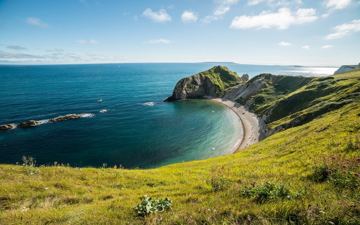 Green hills meet the turquoise sea at Durdle Door, England
