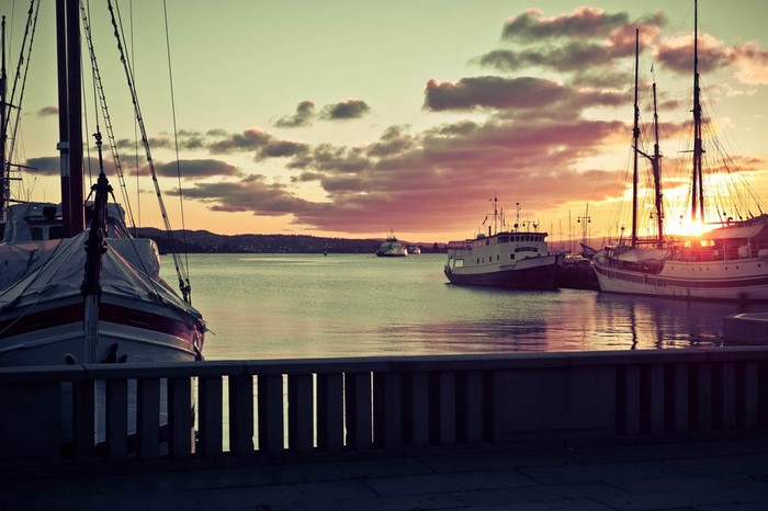 Boats docked in a harbor at sunset in Oslo, Norway