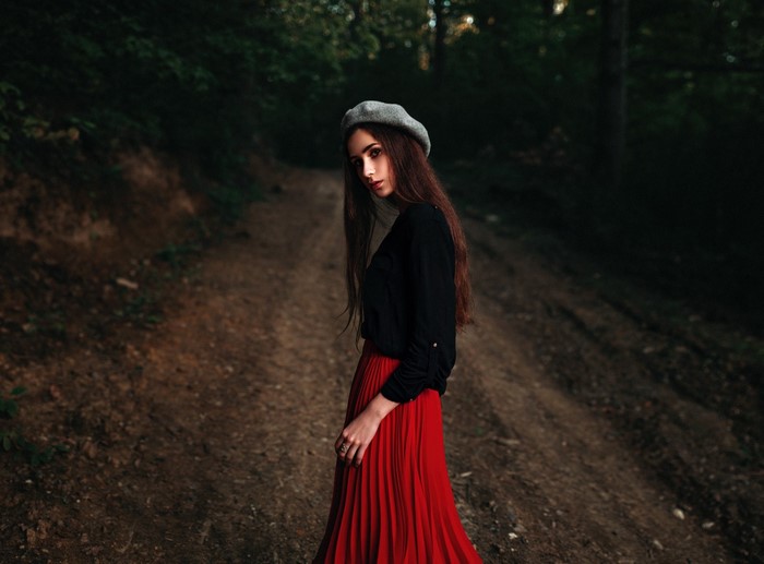 Woman in red skirt and black shirt in forest
