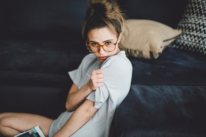 Woman with glasses sitting on a couch