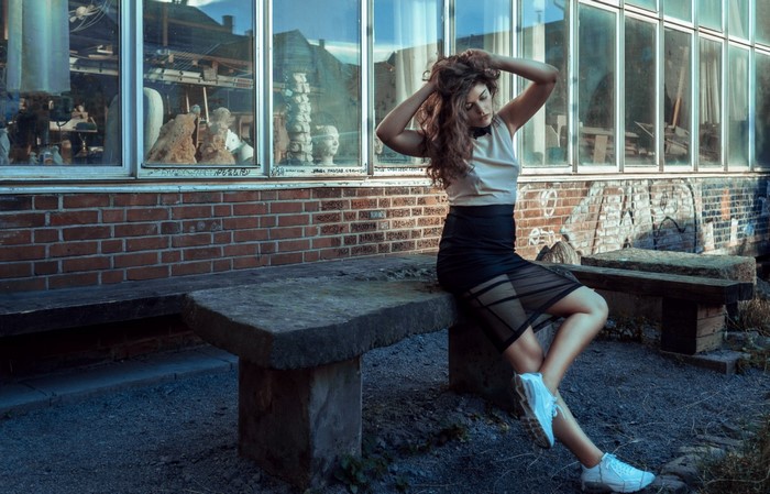 Woman with long hair sitting on a stone bench