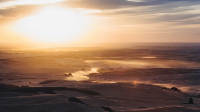 Sunrise over rolling hills with mist