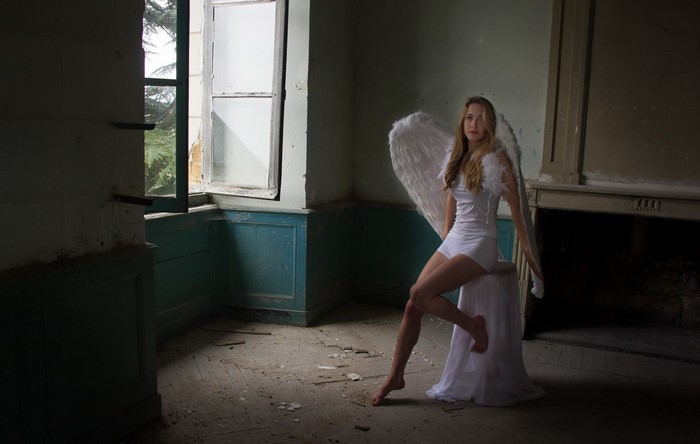 Woman Dressed as Angel in Abandoned Room