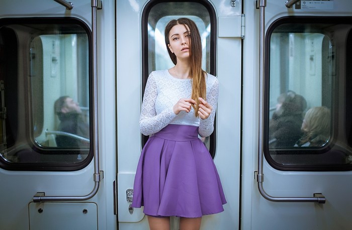 Woman in white top and purple skirt in subway