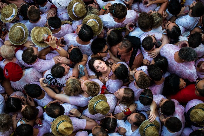 Crowd of people in white shirts and straw hats