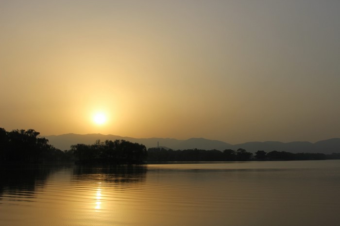 Sunset over a lake with mountains and trees