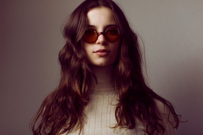Woman with long brown hair and sunglasses