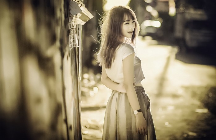 Young Asian woman in a white crop top and skirt