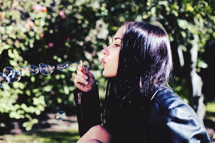 Woman blowing bubbles outdoors