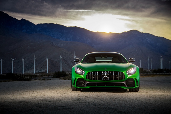 Green Mercedes-AMG GT R in a desert landscape with wind turbines
