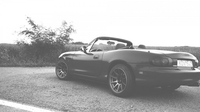 Monochrome Mazda MX-5 convertible parked on a road