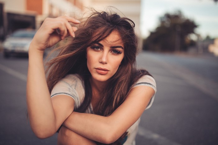 Woman with long brown hair posing outdoors