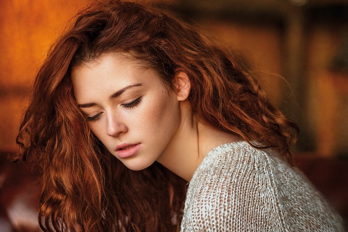 Portrait of a young woman with curly red hair
