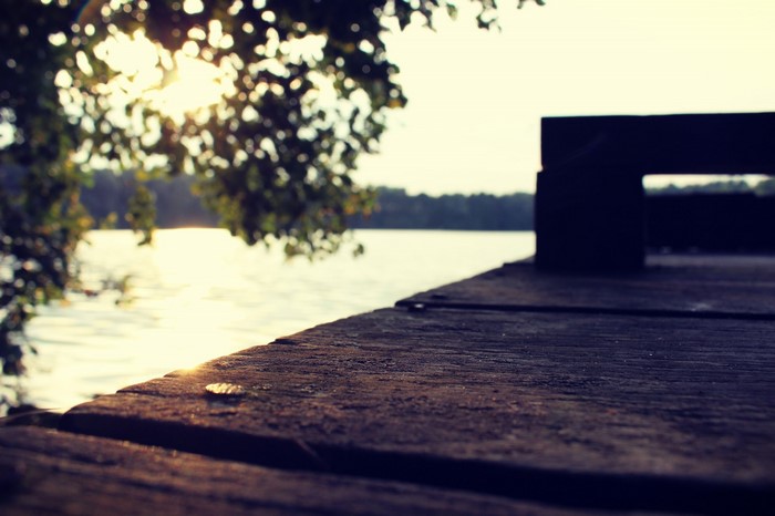 Wooden pier by a lake at sunset