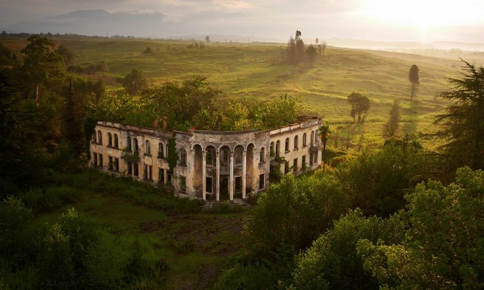 Abandoned building in a green landscape at sunrise