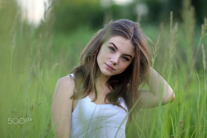 Woman with long brown hair in a grassy meadow