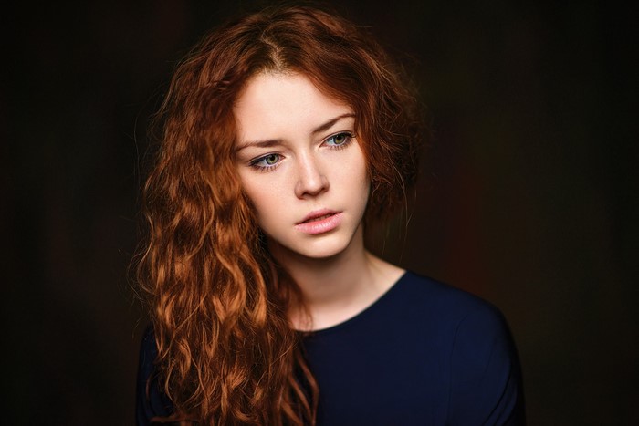 Young woman with long wavy red hair
