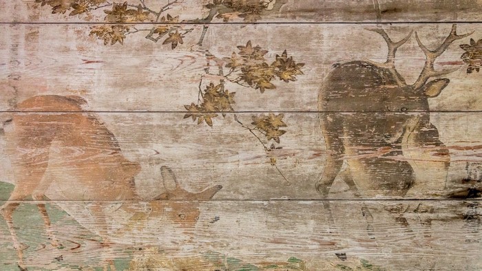 Deer and branches painted on wooden planks